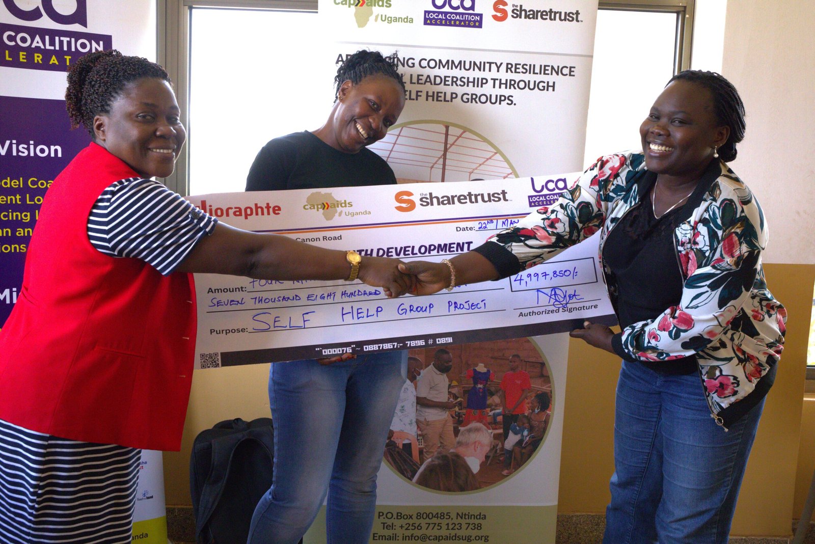 Cheque award presentation to Amaryllis SHG at the Mengo experience-sharing event